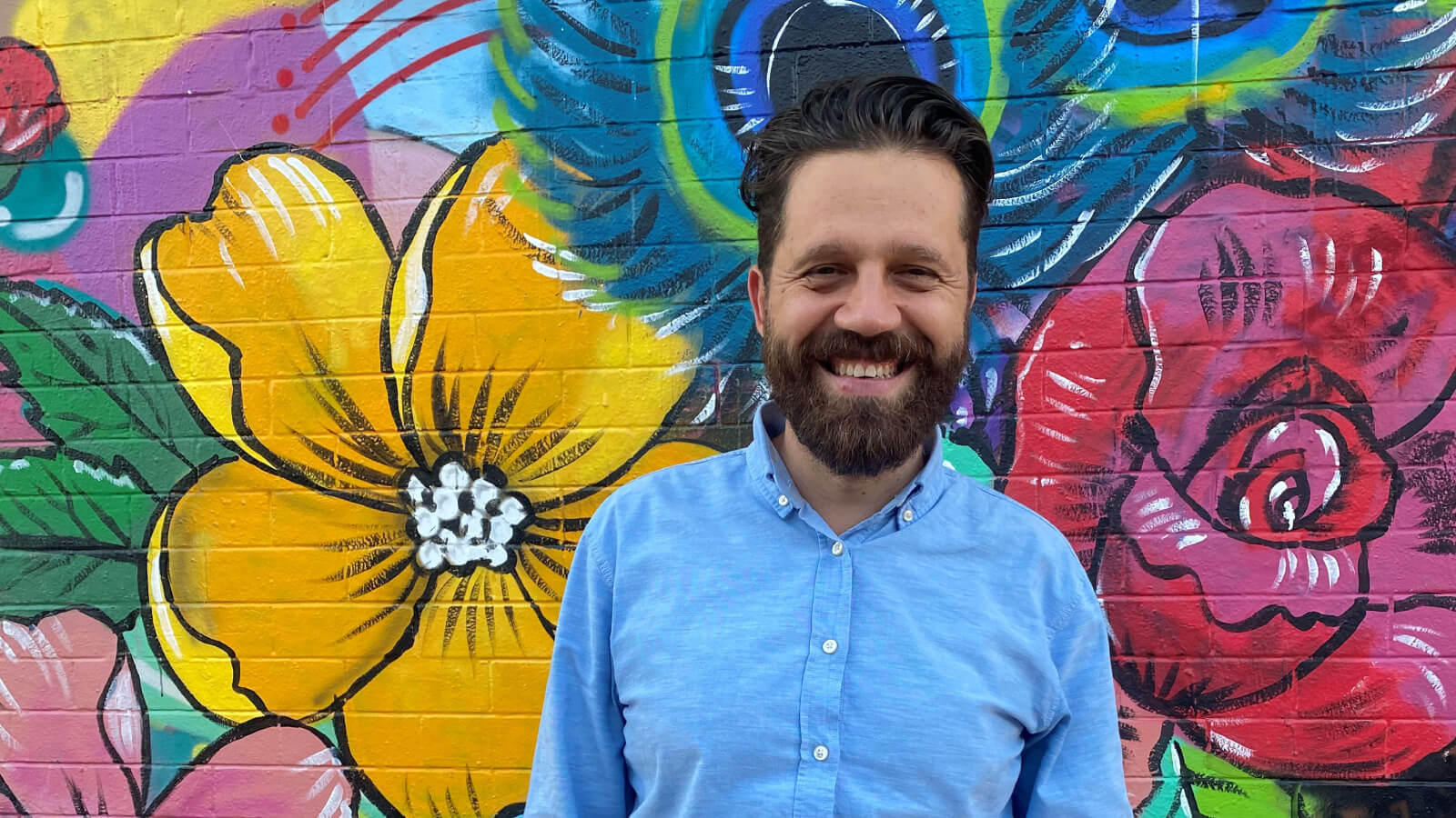 Man in front of mural